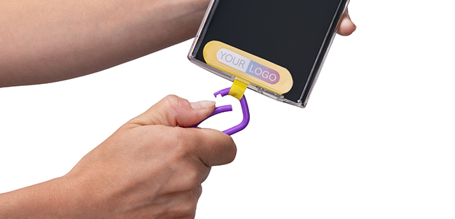 Paso 4 del montaje de lanyard para móvil – inserción del conector phone patch bajo la funda y enganche del grillete.   
